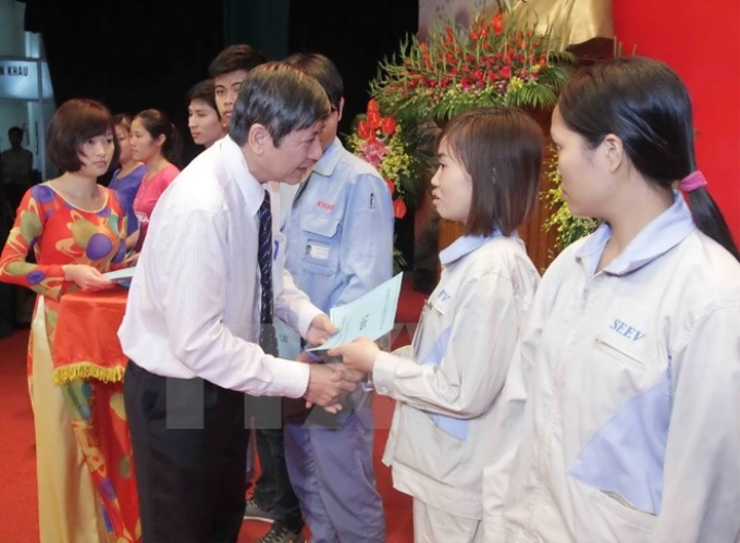 Ông Trần Thanh Hải, Phó Chủ tịch thường trực Tổng Liên đoàn Lao động Việt Nam trao quà cho các công nhân tiêu biểu. (Ảnh: Phương Hoa/TTXVN)